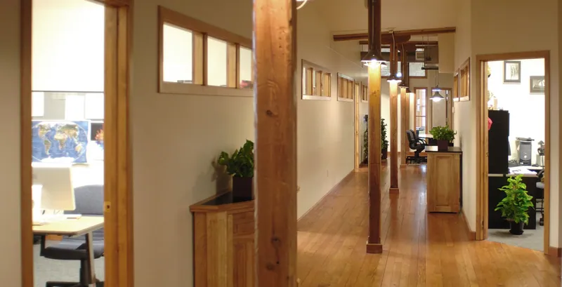 Bellweather office hallway with wood floors, timber posts and transom windows