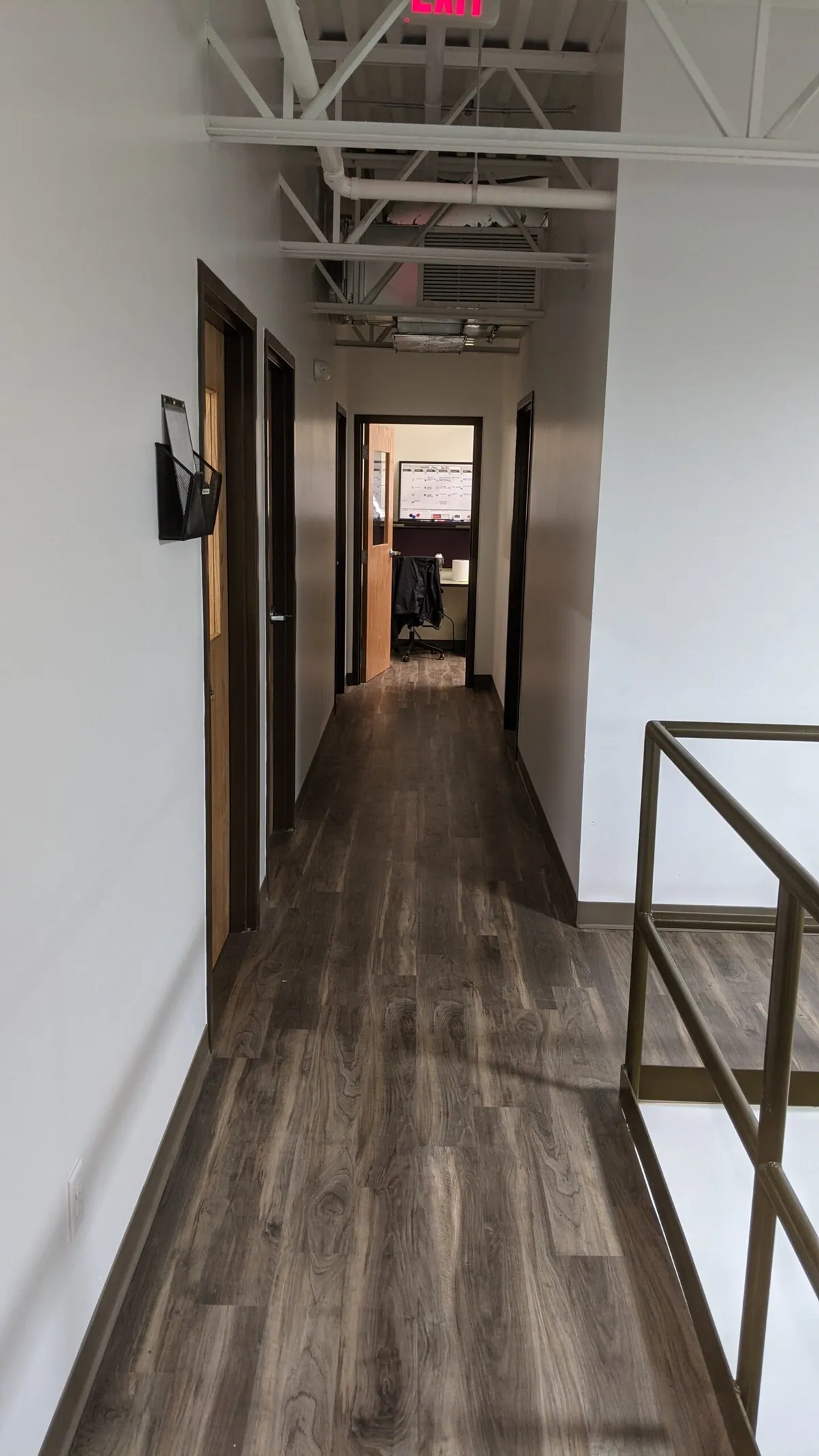 Hallway with wood-look flooring in the commercial buildout