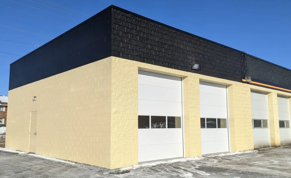 Exterior of a Meineke building with overhead garage doors