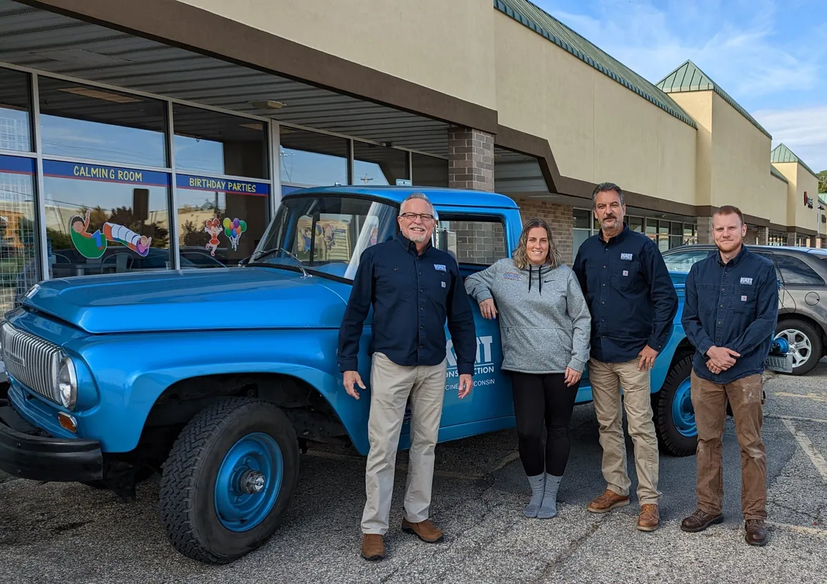 Katt Construction team with the owners of We Rock the Spectrum beside a vintage truck