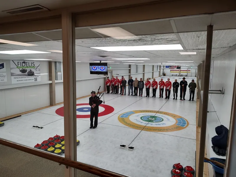 Curlers lined up on the ice at the renovated Racine Curling Club