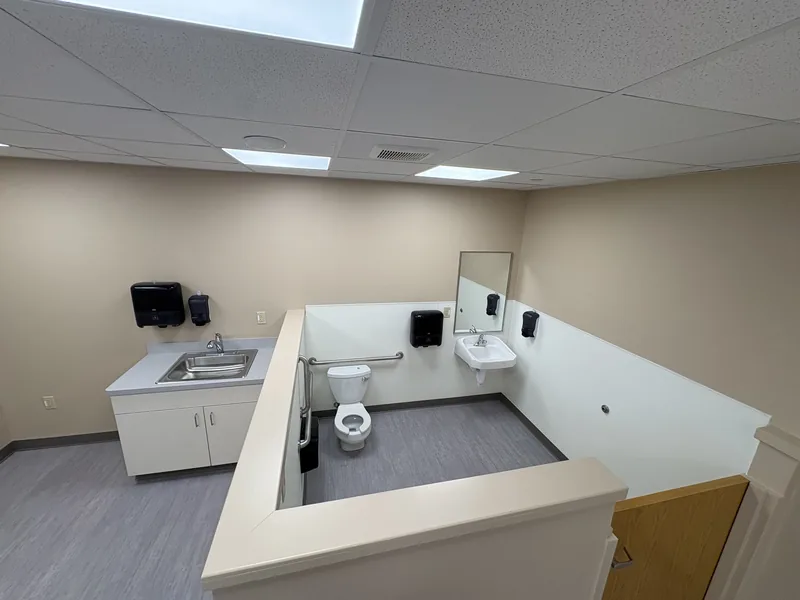 Renovated daycare restroom area with child-height half walls