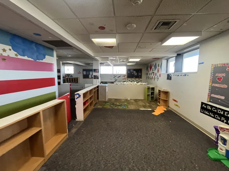 Daycare classroom before renovation, with carpet and shelving
